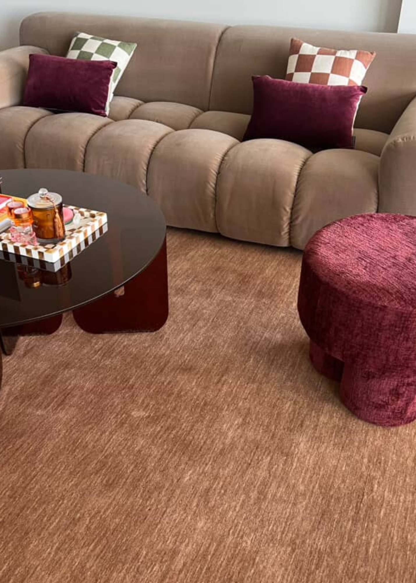 Living room with a brown sofa, burgundy ottoman, and coffee table on Wool Texture Teddy Brown Rug by Four Corners Rugs 